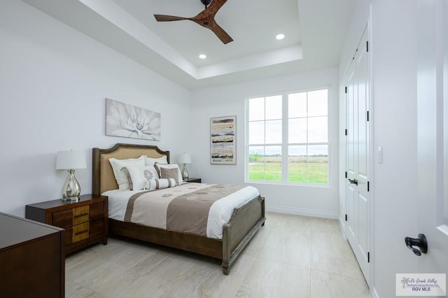 bedroom featuring ceiling fan and a raised ceiling