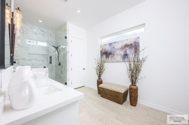 bathroom featuring walk in shower, vanity, and plenty of natural light