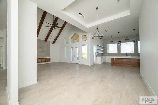 unfurnished living room featuring high vaulted ceiling, ceiling fan with notable chandelier, sink, beam ceiling, and light hardwood / wood-style floors