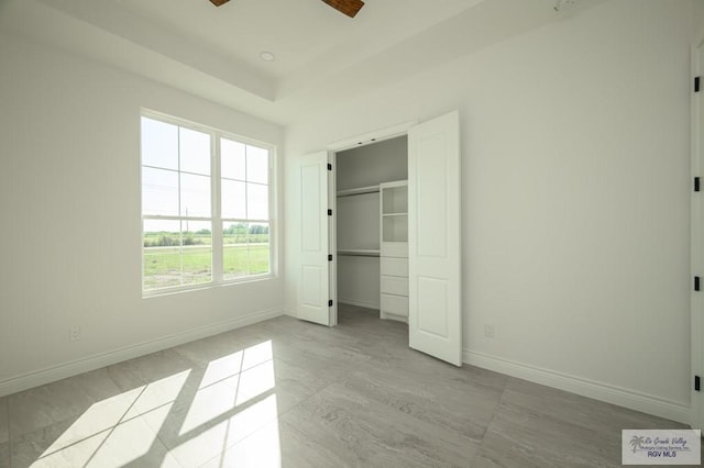 unfurnished bedroom with ceiling fan and a closet