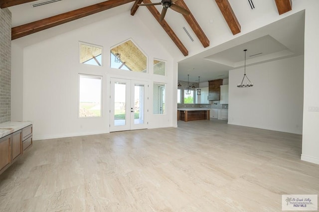 unfurnished living room featuring beam ceiling, high vaulted ceiling, plenty of natural light, and ceiling fan