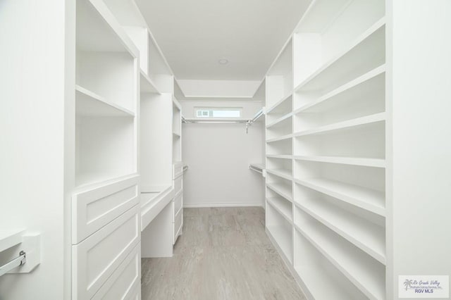 spacious closet with light hardwood / wood-style floors