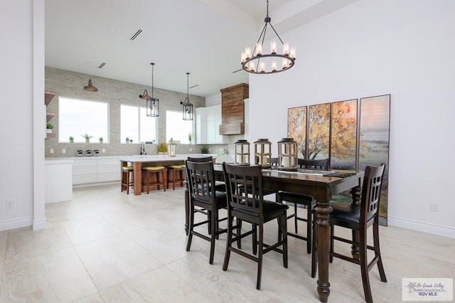 dining area featuring light tile patterned floors and an inviting chandelier