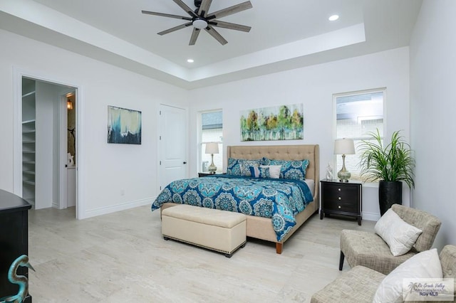 bedroom with a tray ceiling and ceiling fan