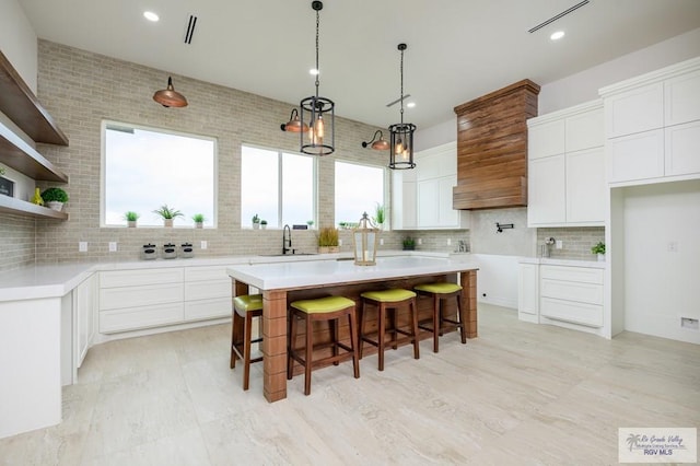 kitchen with white cabinets, a kitchen island, and sink