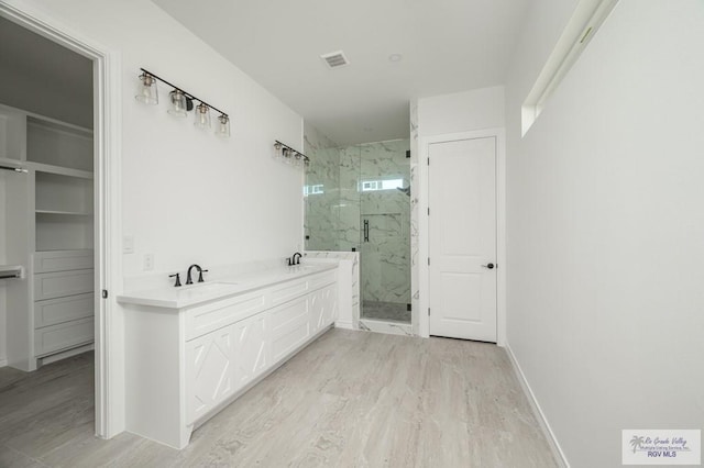 bathroom with a shower with door, vanity, and wood-type flooring