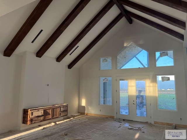 unfurnished living room featuring beam ceiling, french doors, and high vaulted ceiling