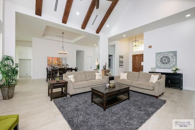 living room with beamed ceiling, high vaulted ceiling, a chandelier, and light hardwood / wood-style floors