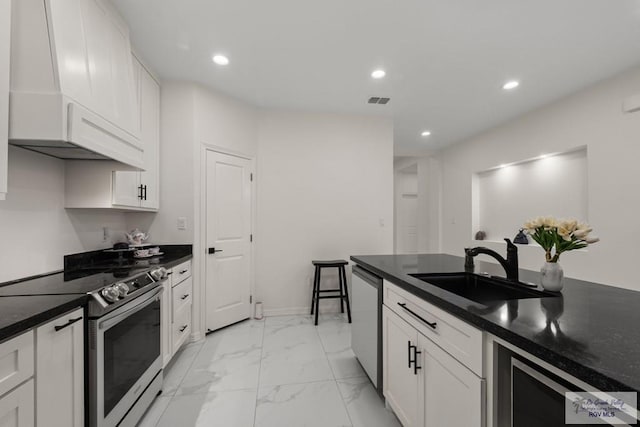 kitchen with premium range hood, stainless steel appliances, wine cooler, white cabinets, and sink