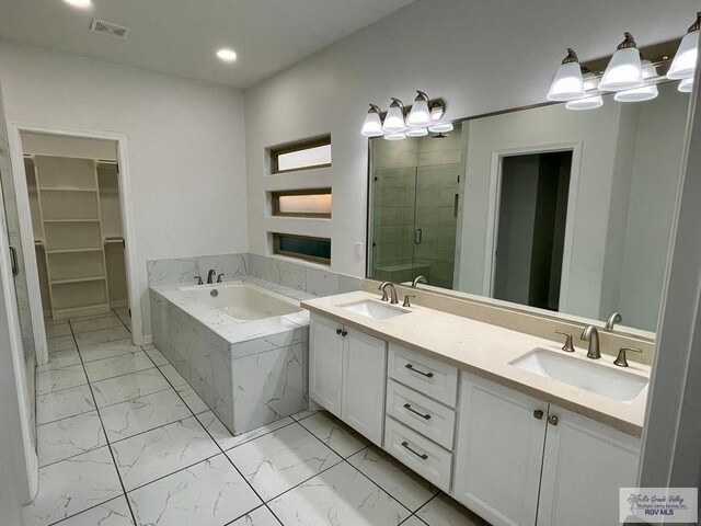 bathroom with vanity and shower with separate bathtub