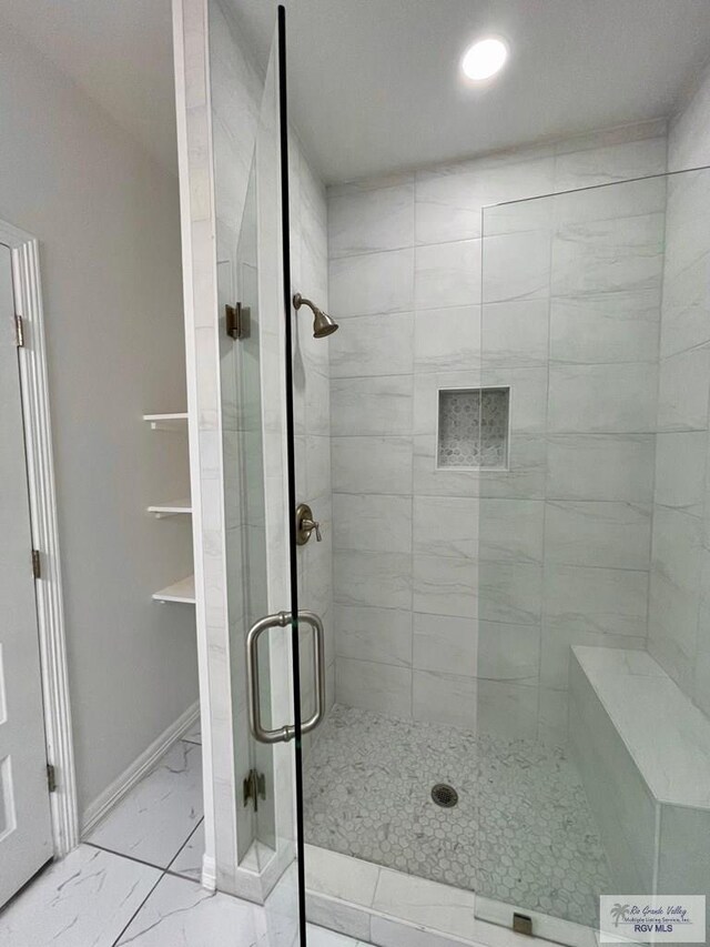 bathroom featuring a shower with door