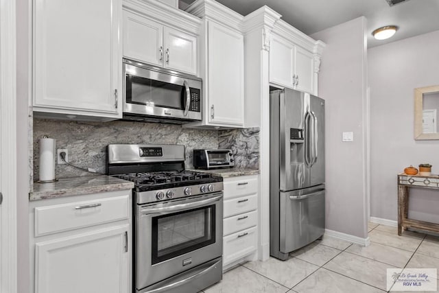 34164 Quail Dr, San Benito, TX 78586 - kitchen with appliances with stainless steel finishes, white cabinets, decorative backsplash, light stone countertops, and baseboards