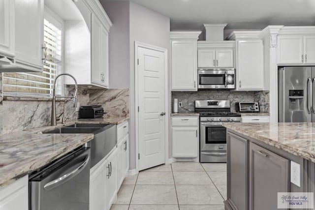 34164 Quail Dr, San Benito, TX 78586 - kitchen with stainless steel appliances, a sink, white cabinetry, and backsplash