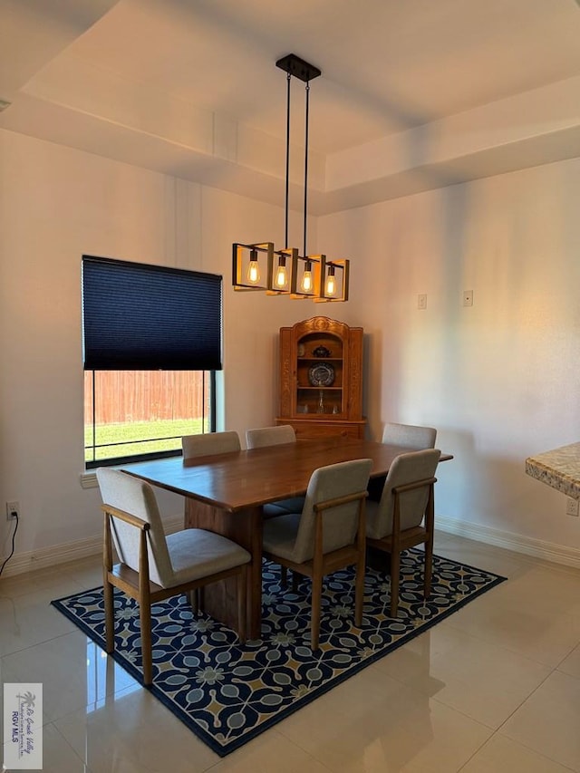 tiled dining room with a raised ceiling