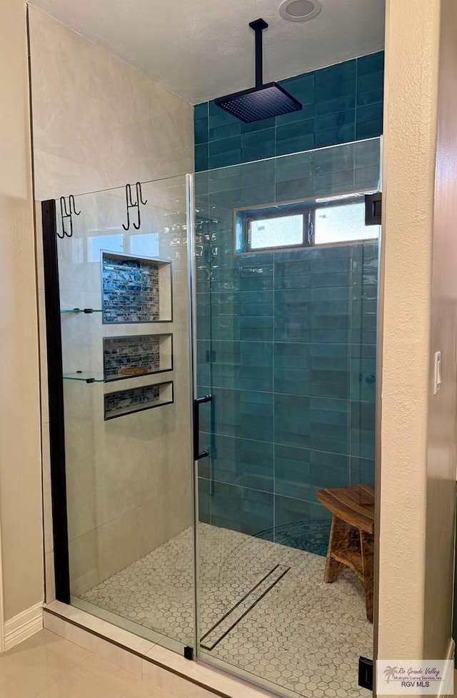 bathroom featuring walk in shower and tile patterned flooring