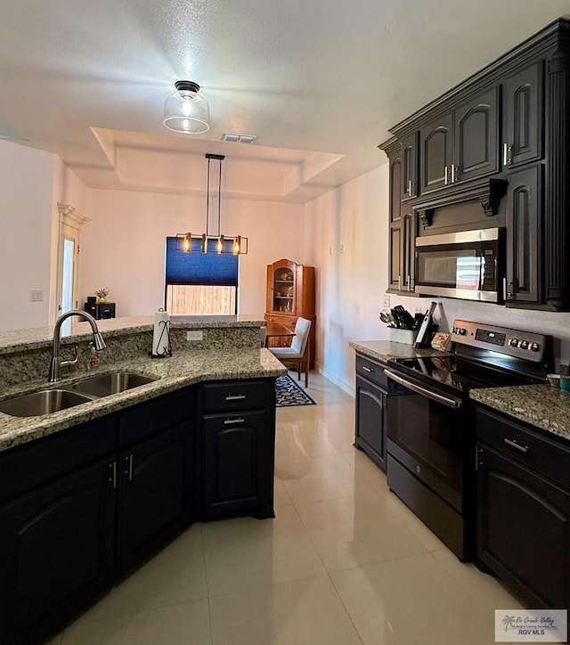 kitchen with pendant lighting, sink, a raised ceiling, and appliances with stainless steel finishes