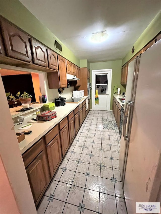 kitchen with light tile patterned floors and stainless steel appliances