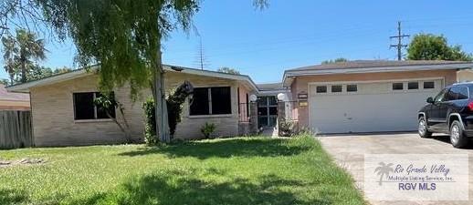 single story home featuring a front lawn and a garage