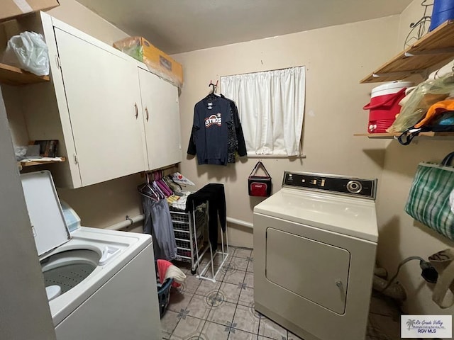 laundry room featuring separate washer and dryer and cabinets