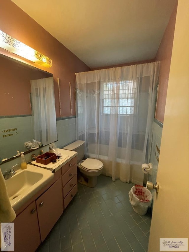 full bathroom featuring vanity, shower / bathtub combination with curtain, toilet, and tile walls