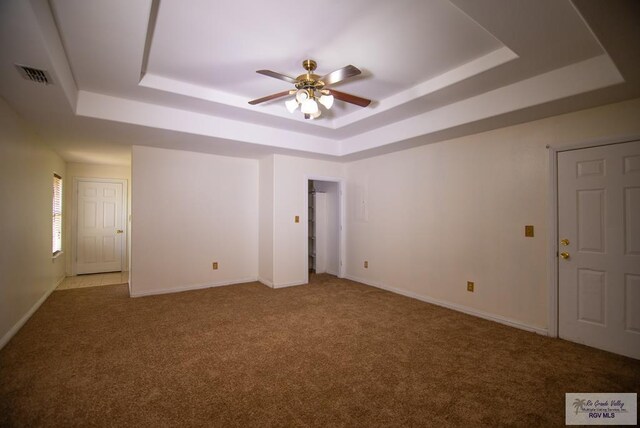 3630 Sun Dr, Harlingen, TX 78552 - carpeted spare room featuring a tray ceiling, ceiling fan, and baseboards