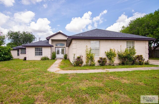 3630 Sun Dr, Harlingen, TX 78552 - ranch-style house with french doors, a front yard, brick siding, and a shingled roof