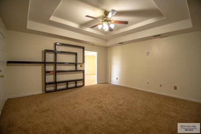 3630 Sun Dr, Harlingen, TX 78552 - spare room featuring a raised ceiling, a ceiling fan, carpet, and baseboards