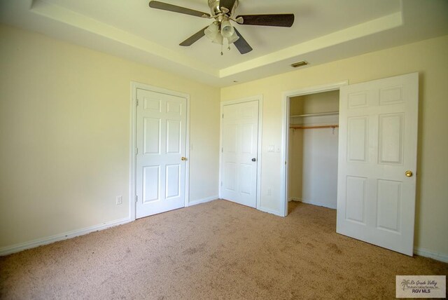 3630 Sun Dr, Harlingen, TX 78552 - unfurnished bedroom featuring a tray ceiling, carpet floors, a closet, and baseboards