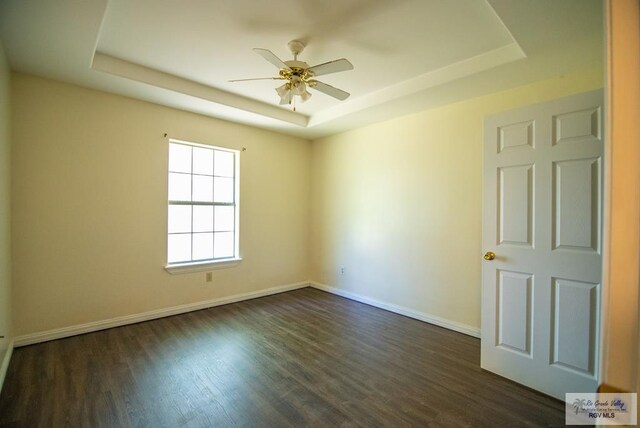 3630 Sun Dr, Harlingen, TX 78552 - unfurnished room with a raised ceiling, ceiling fan, baseboards, and dark wood-type flooring