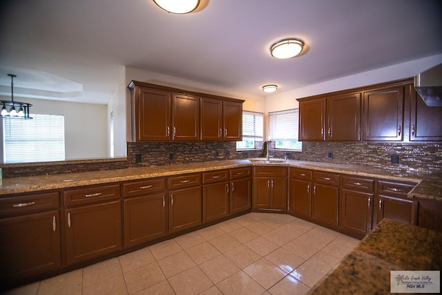 3630 Sun Dr, Harlingen, TX 78552 - kitchen with decorative backsplash, light tile patterned floors, a chandelier, and a sink