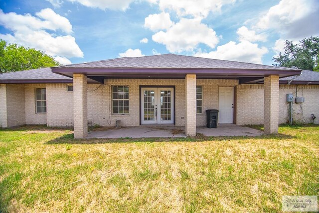 3630 Sun Dr, Harlingen, TX 78552 - back of house with french doors, a patio, a lawn, and brick siding