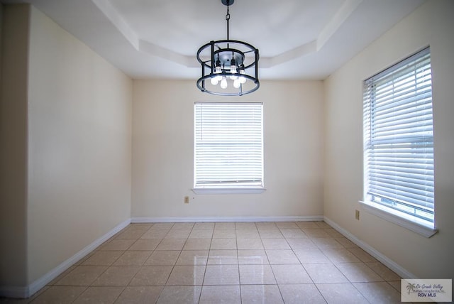 3630 Sun Dr, Harlingen, TX 78552 - spare room with a chandelier, healthy amount of natural light, a tray ceiling, and light tile patterned floors