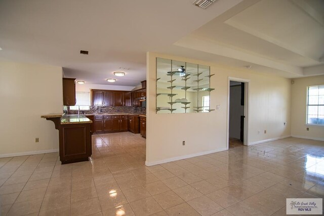 3630 Sun Dr, Harlingen, TX 78552 - kitchen with light tile patterned floors, baseboards, and open floor plan