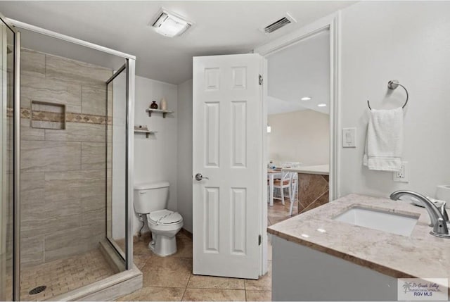 bathroom featuring tile patterned flooring, vanity, toilet, and a shower with shower door