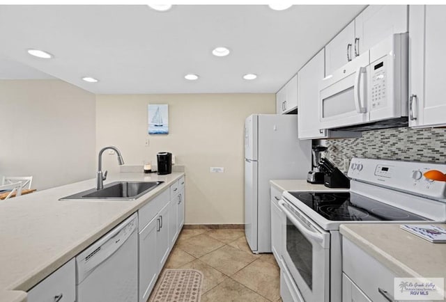 kitchen with sink, light tile patterned floors, white appliances, decorative backsplash, and white cabinets