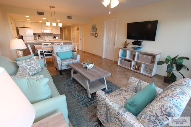 tiled living room with ceiling fan