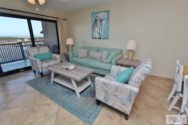 tiled living room featuring ceiling fan and a water view