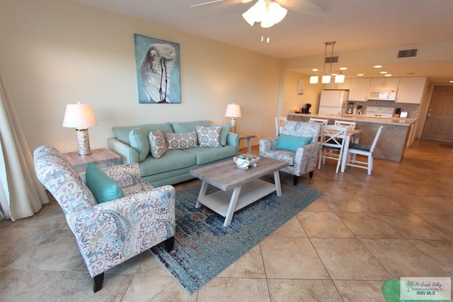 living room with ceiling fan and light tile patterned flooring