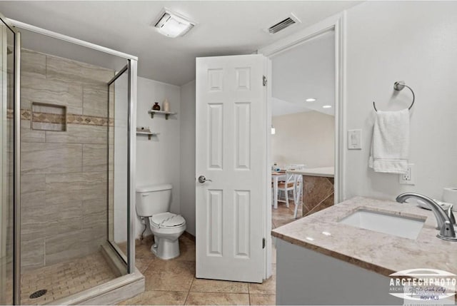 bathroom with an enclosed shower, vanity, toilet, and tile patterned floors