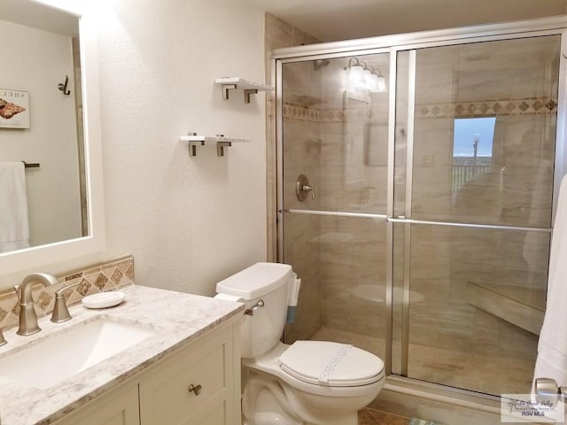 bathroom featuring vanity, toilet, and walk in shower