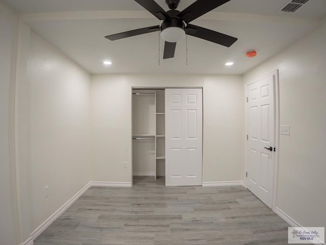 unfurnished bedroom featuring a closet, ceiling fan, and light hardwood / wood-style flooring