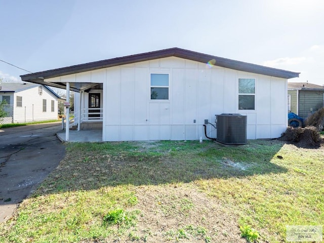 view of side of home featuring a patio, a lawn, and central air condition unit