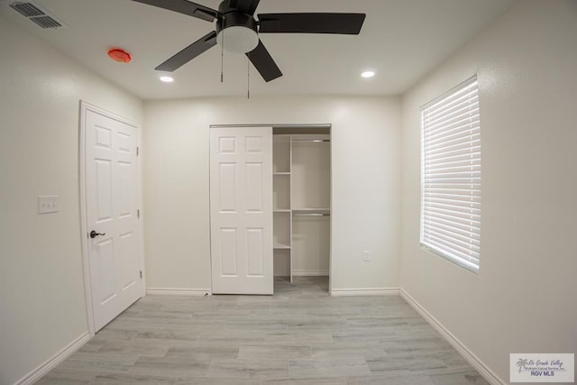 unfurnished bedroom with ceiling fan, a closet, and light wood-type flooring