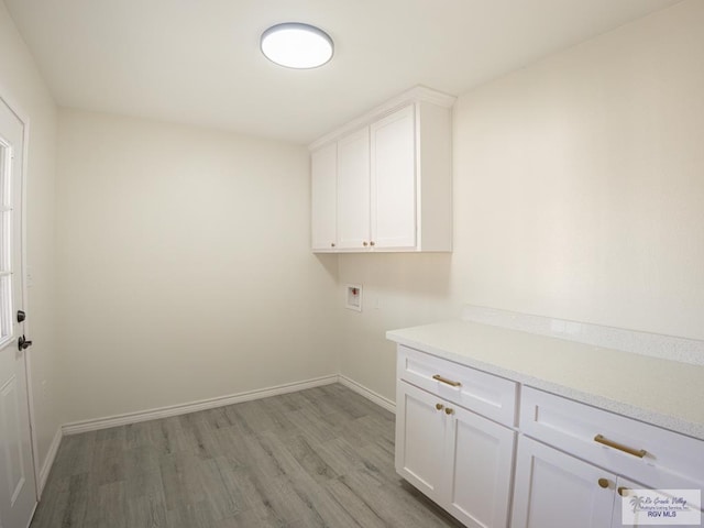 clothes washing area with cabinets, hookup for a washing machine, and light wood-type flooring