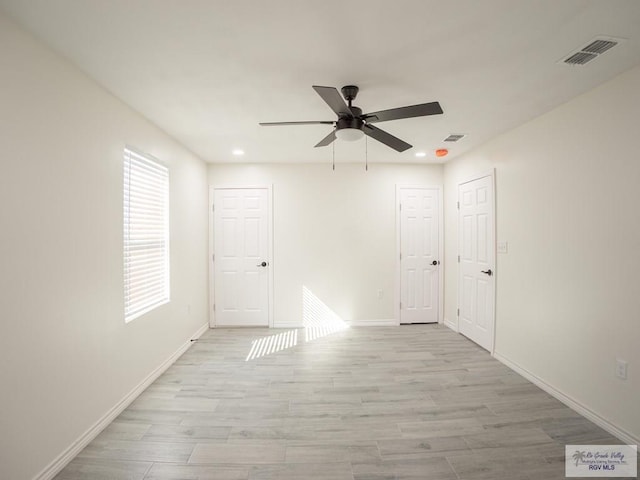 empty room with ceiling fan and light wood-type flooring