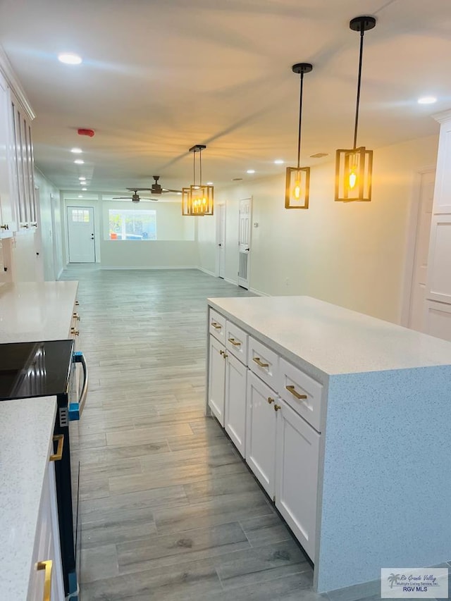 kitchen featuring electric stove, ceiling fan, white cabinetry, hanging light fixtures, and hardwood / wood-style floors