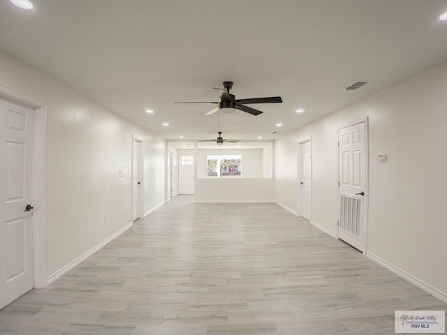 empty room with ceiling fan and light hardwood / wood-style flooring