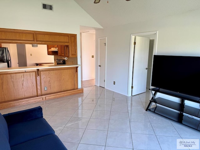 living area featuring light tile patterned floors, visible vents, baseboards, ceiling fan, and high vaulted ceiling