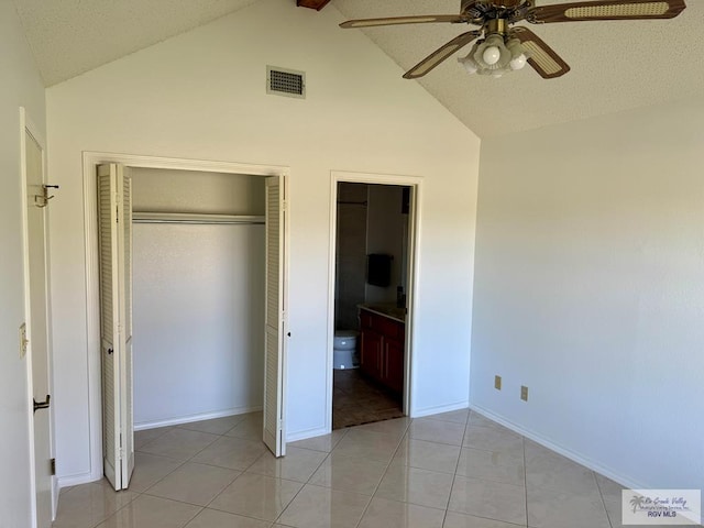 unfurnished bedroom with light tile patterned floors, a closet, visible vents, ceiling fan, and ensuite bath