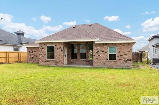 rear view of house featuring a patio and a lawn